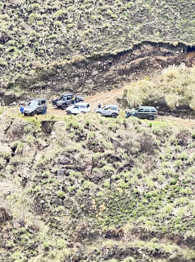Los vehículos formados sobre el filo del camino, vistos desde el otro lado de la quebrada