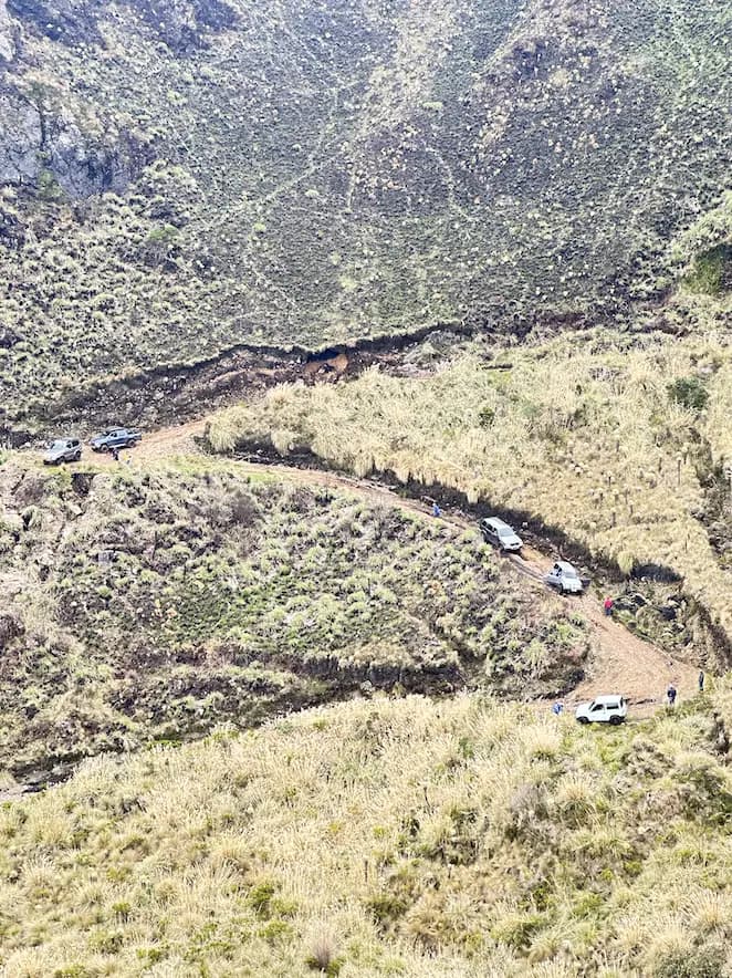 La caravana bajando por las curvas del camino de tierra, vista desde lo alto del páramo