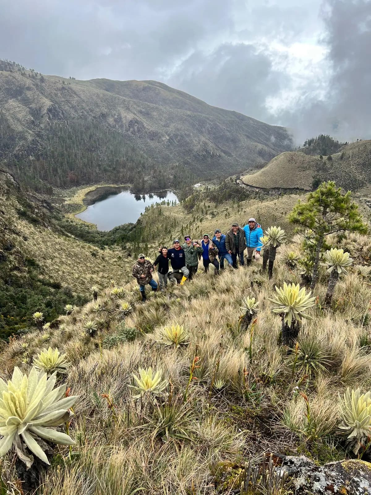 El grupo posando entre los frailejones, con la laguna y la neblina del páramo detrás